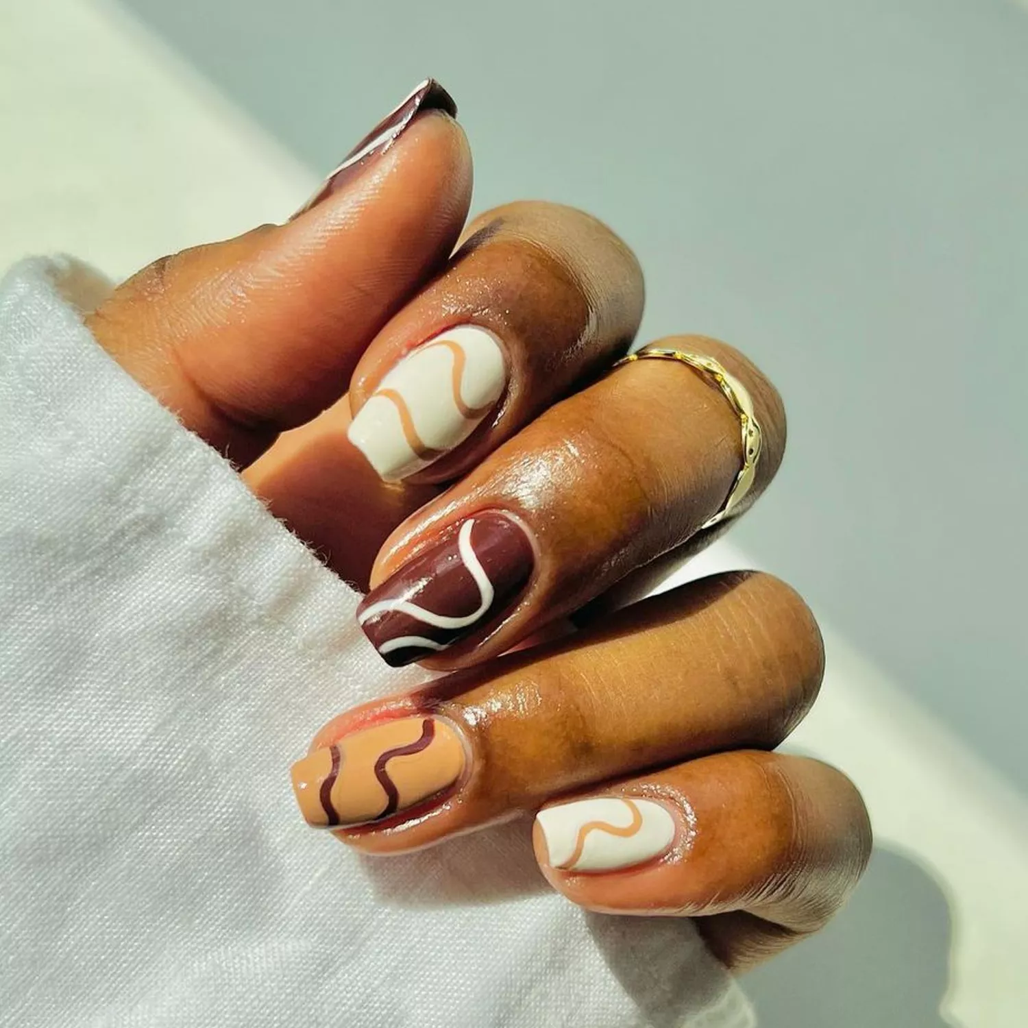 An assorted chocolates mani with squiggly details on each fingernail