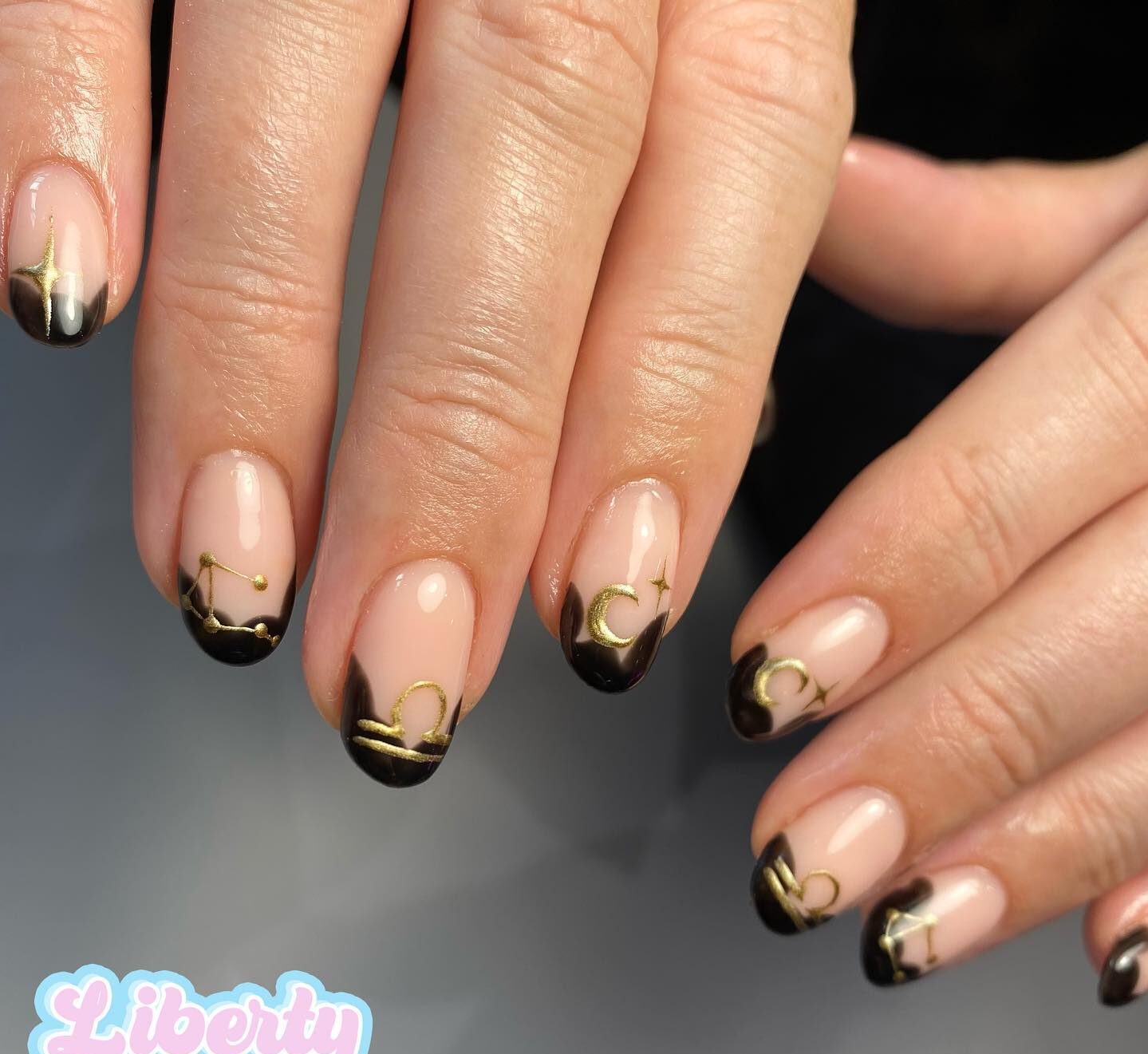 Black abstract French tips with gold Libra sign and celestial elements nail arts on short round nails