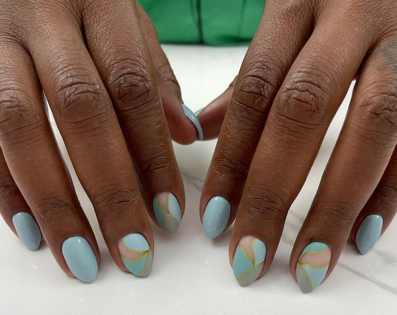 Pale blue nail polish with abstract nail art on medium almond nails