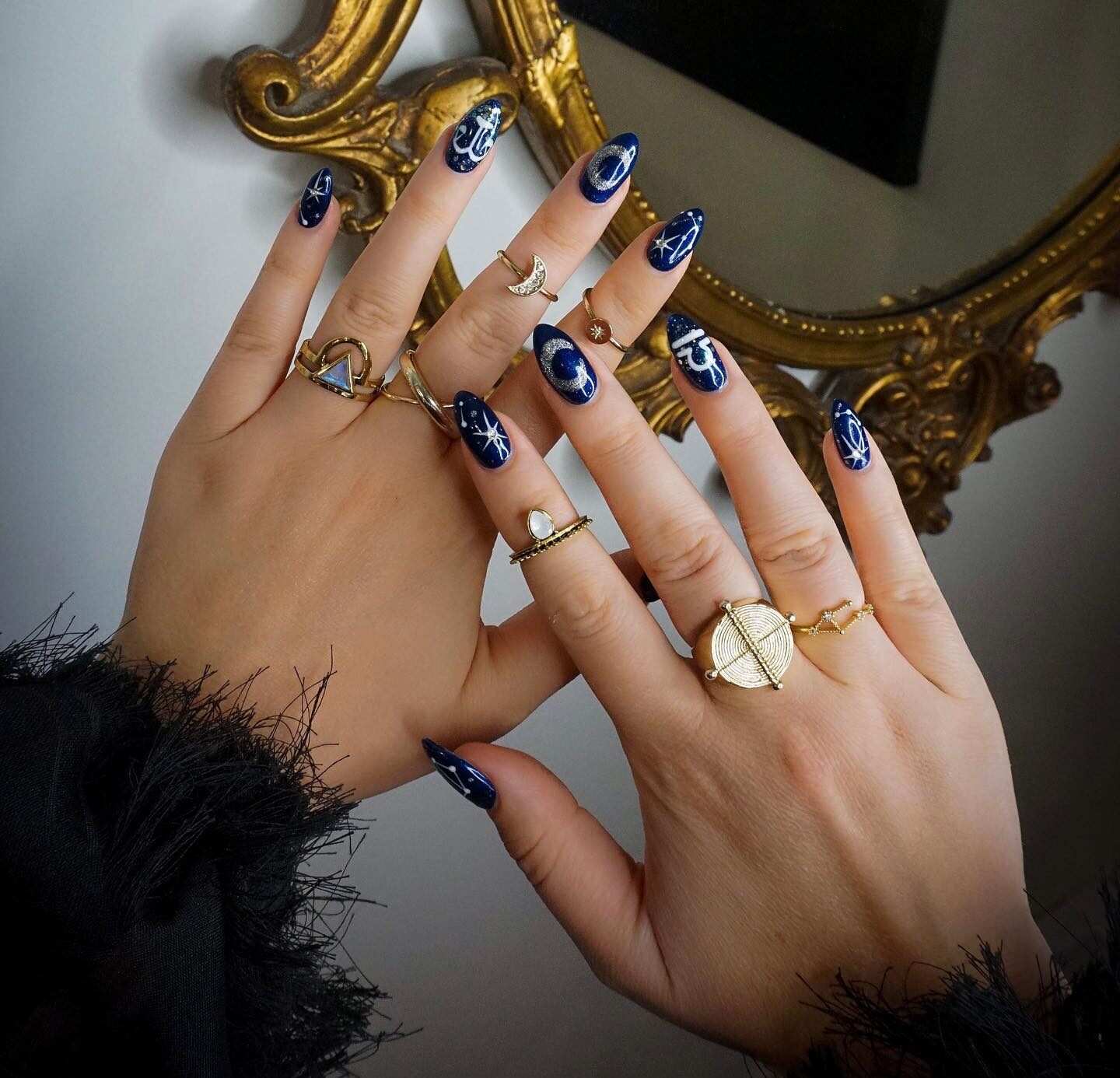 Dark blue nail color with Libra sign and celestial elements nail arts on medium almond nails