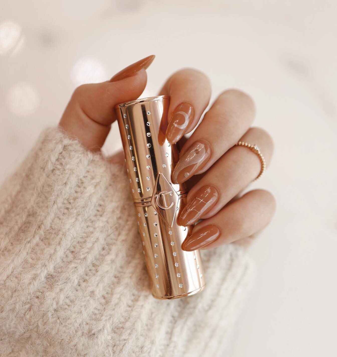 Brown nail polish with celestial elements nail design on long round nails