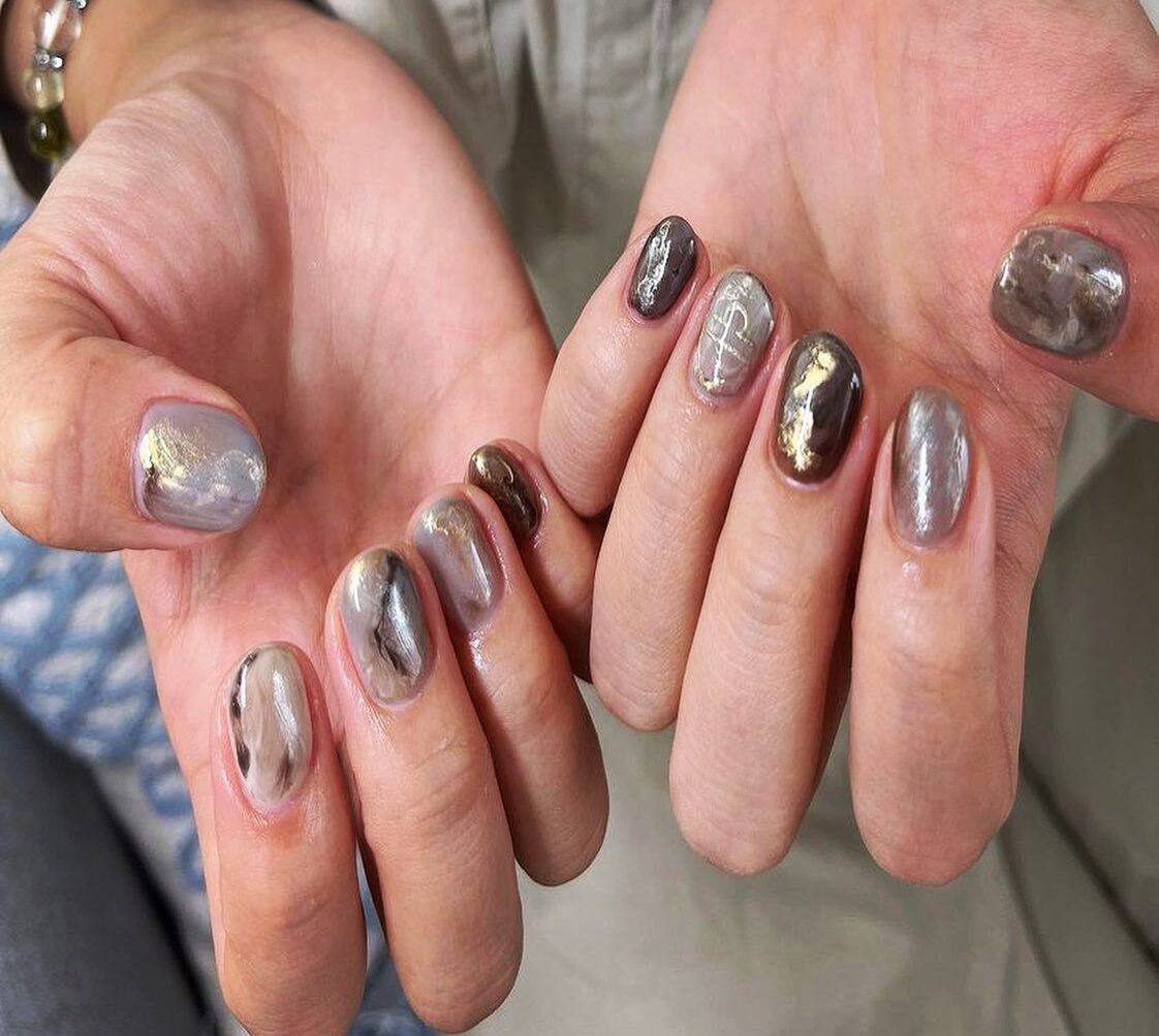 Glossy gray marble nail design with gold foil on short round nails