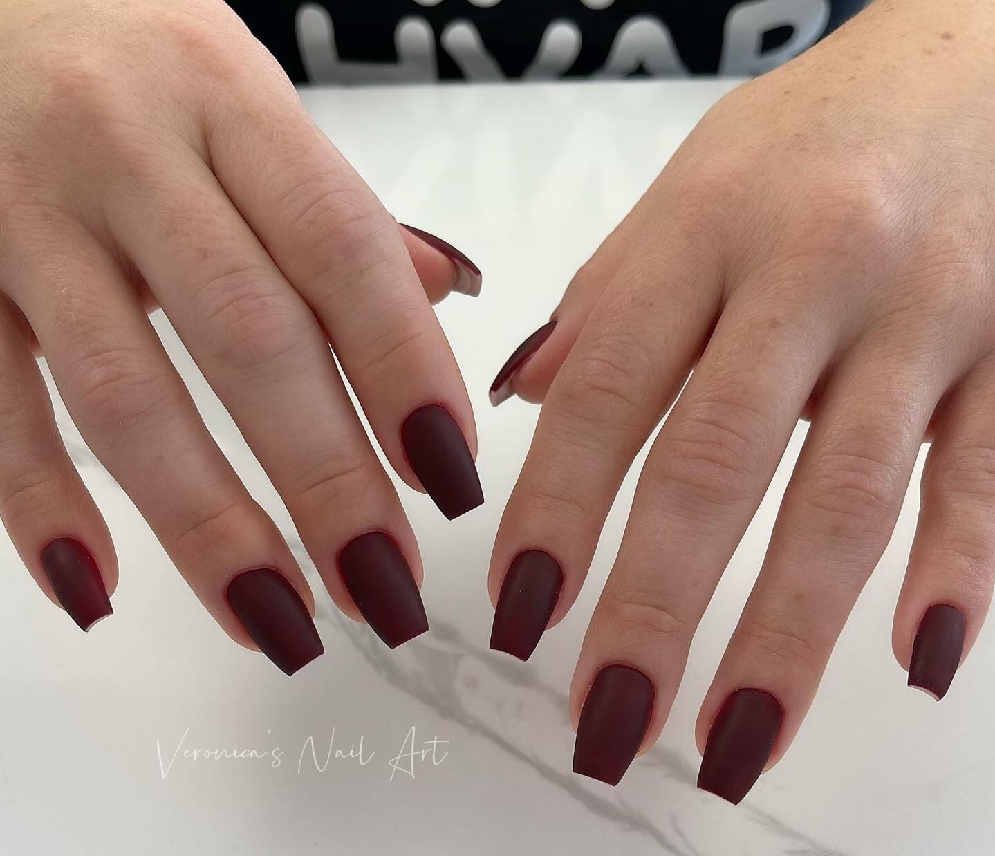 Plain matte finish maroon nail color on medium tapered square nails