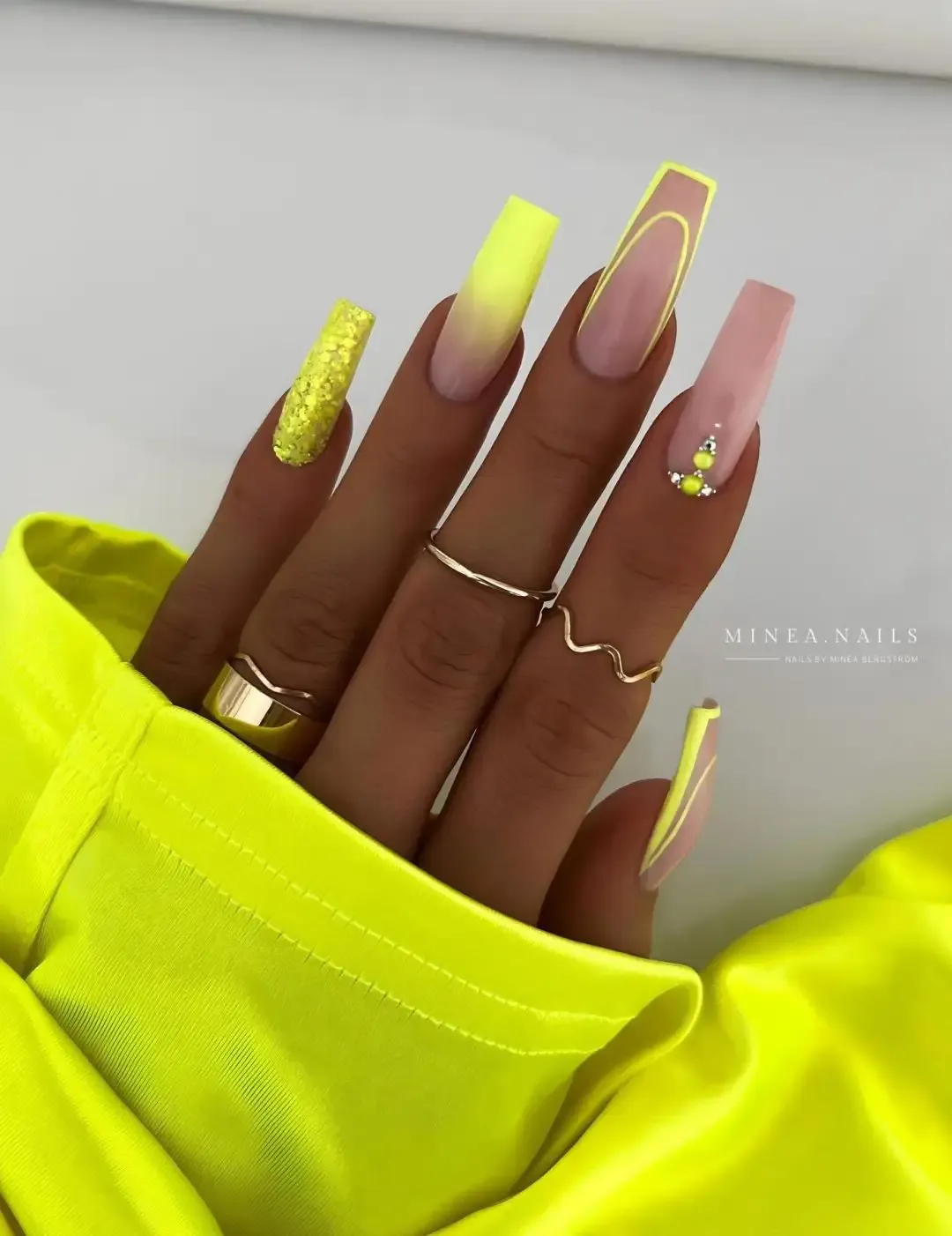 Neon yellow nails with glitter and French tip nails.