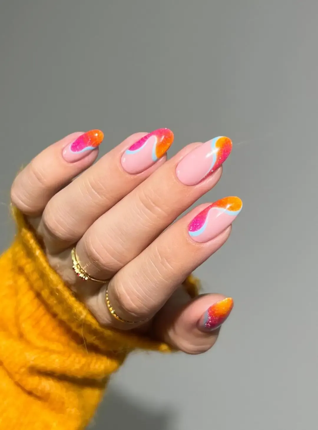 Neon pink and orange swirl nails.