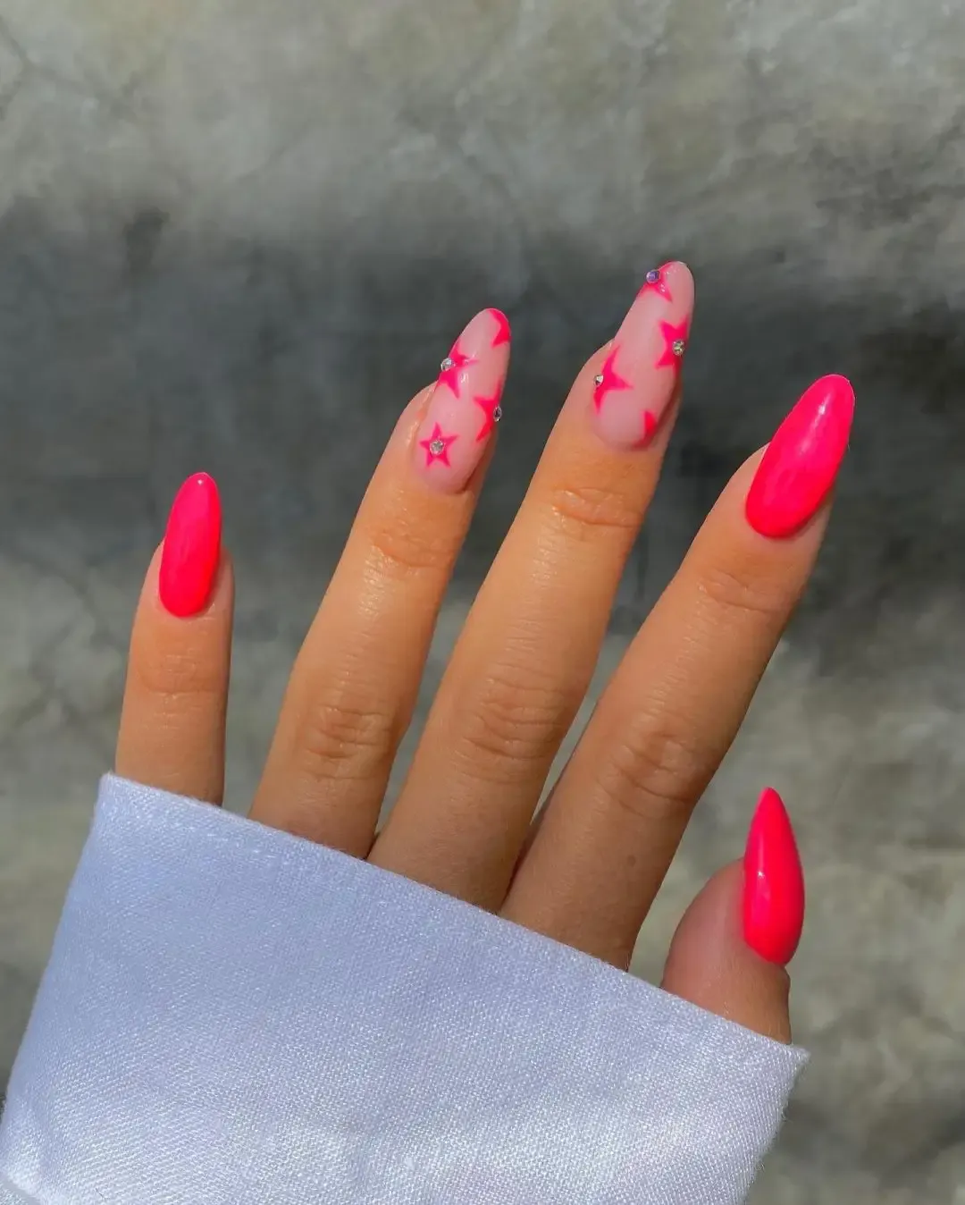 Neon pink nails with stars.