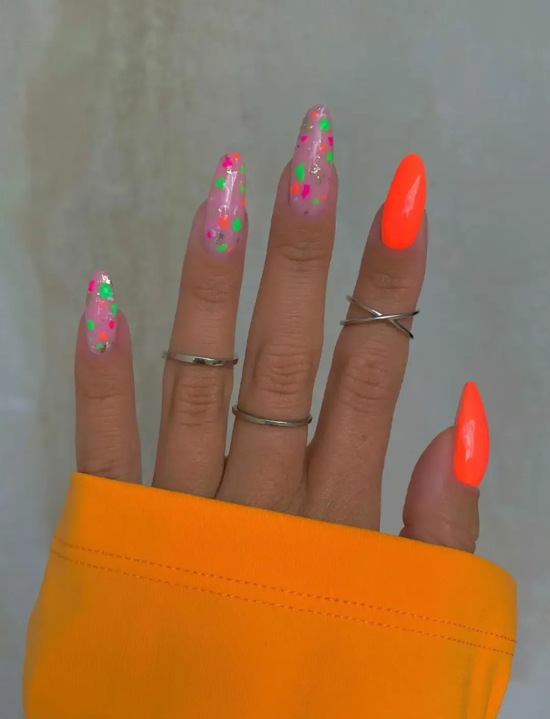 Neon orange nails with terrazzo effect.