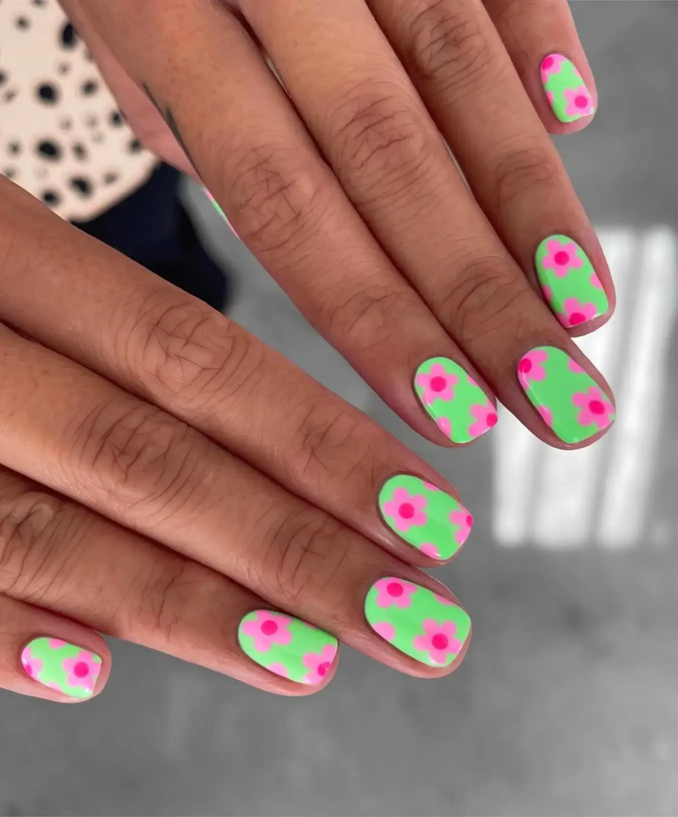 Short neon green nails with pink flowers.