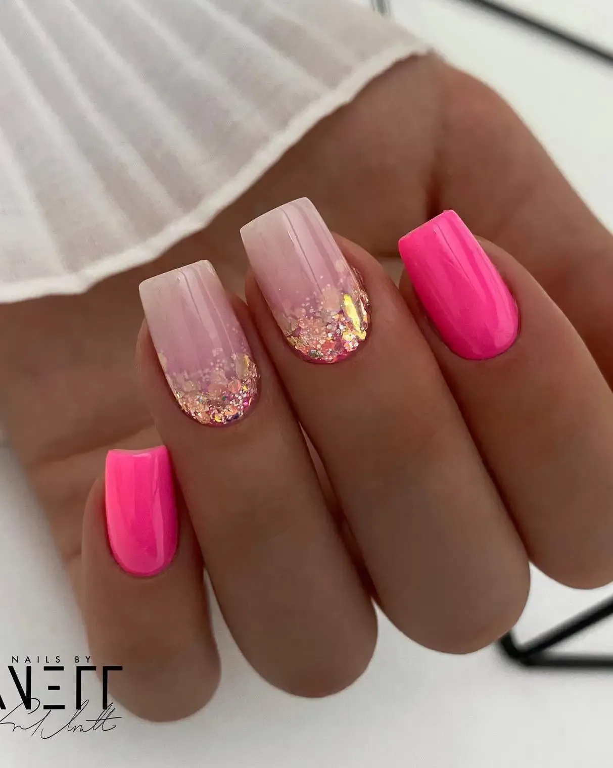 Neon pink nails with glitter.