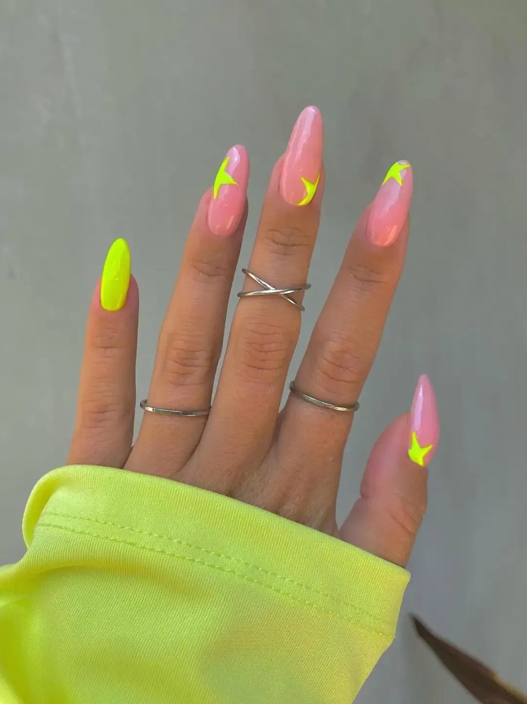 Neon yellow nails with stars.