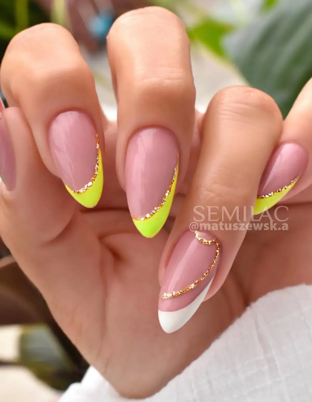 Neon yellow French tip nails with glitter.