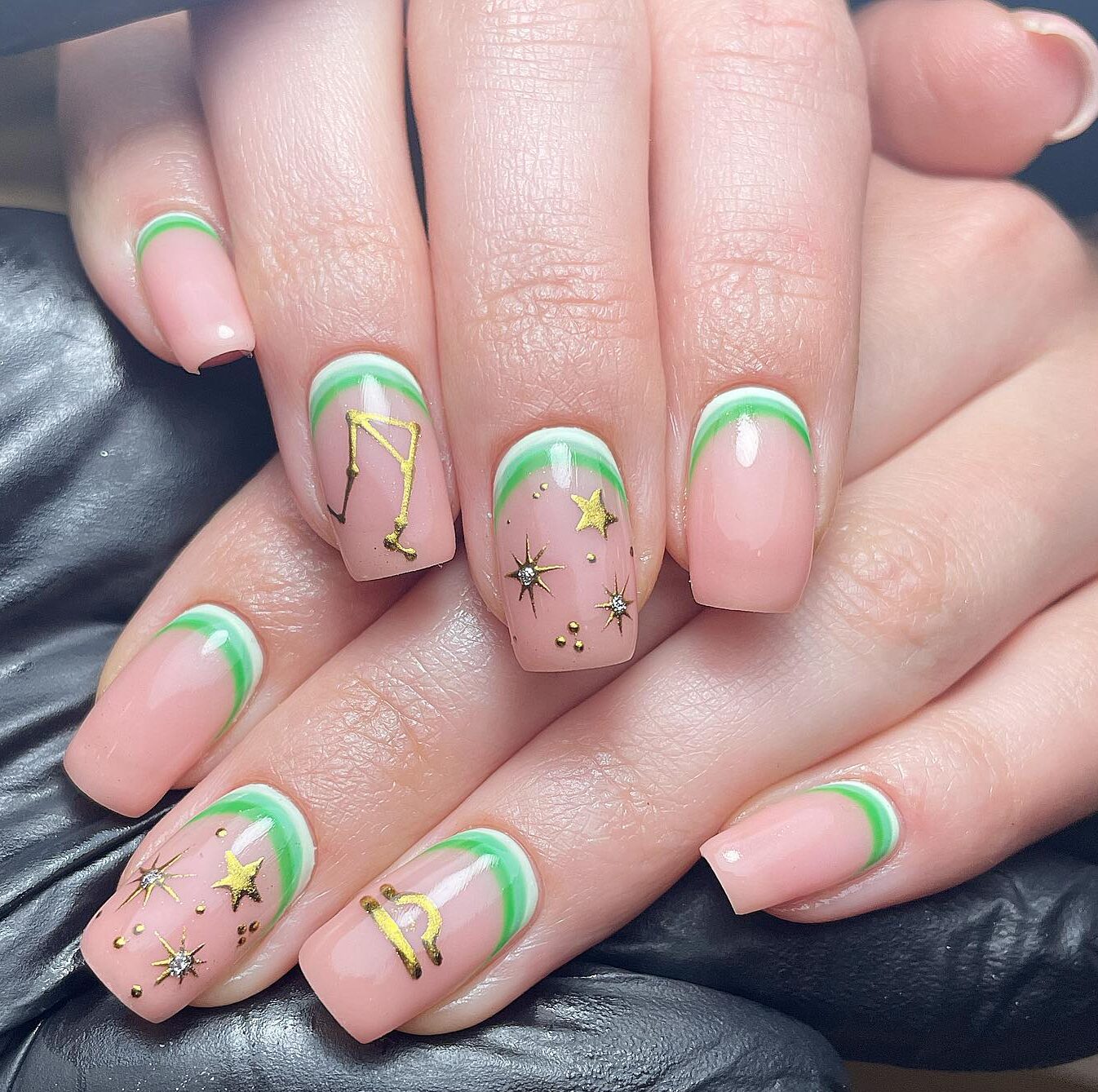 Nude nail color with gold Libra sign, constellation, and celestial elements nail arts on short square nails