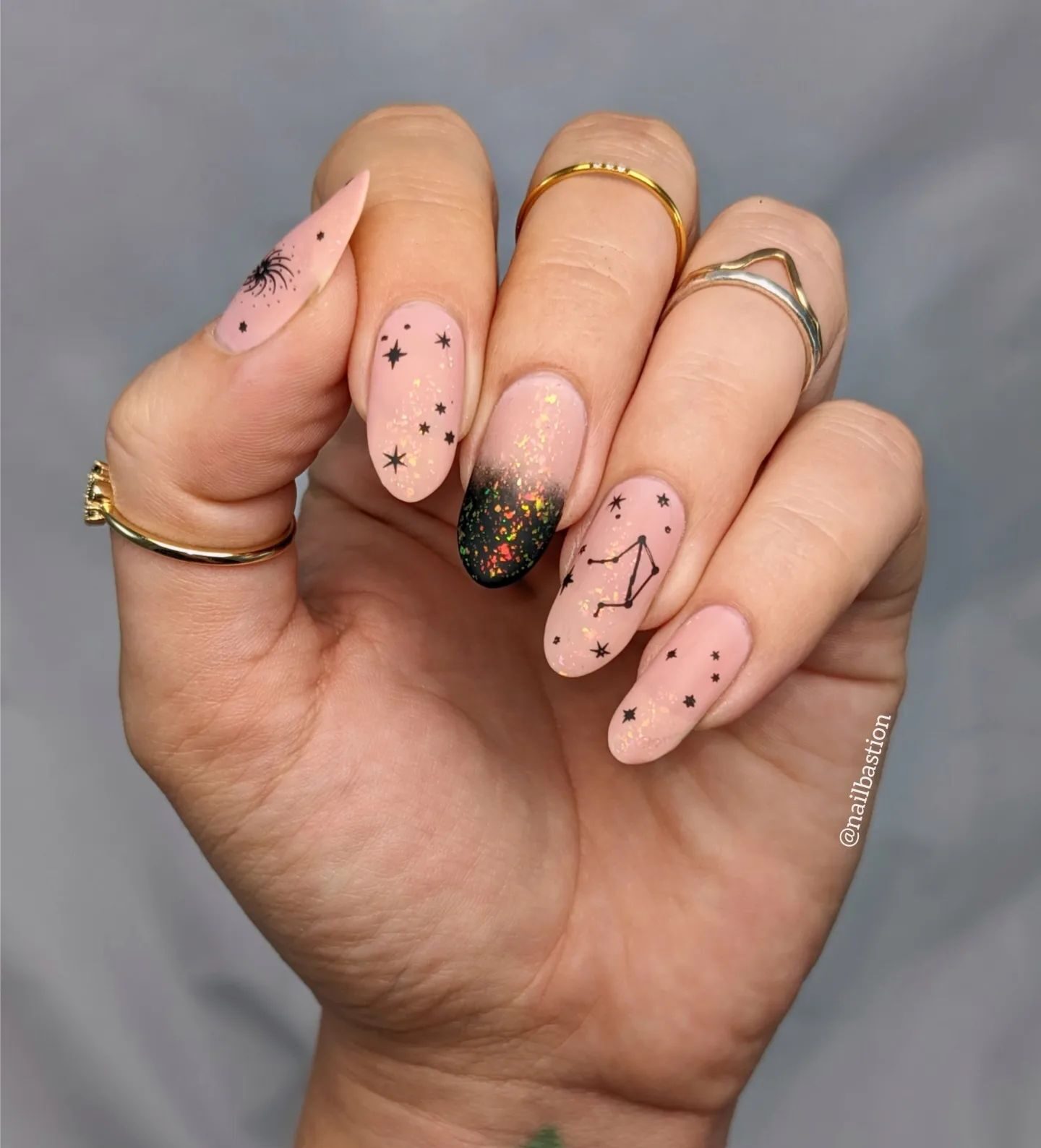 Matte finish nude nail color with black Libra constellation and celestial elements nail arts on long round nails