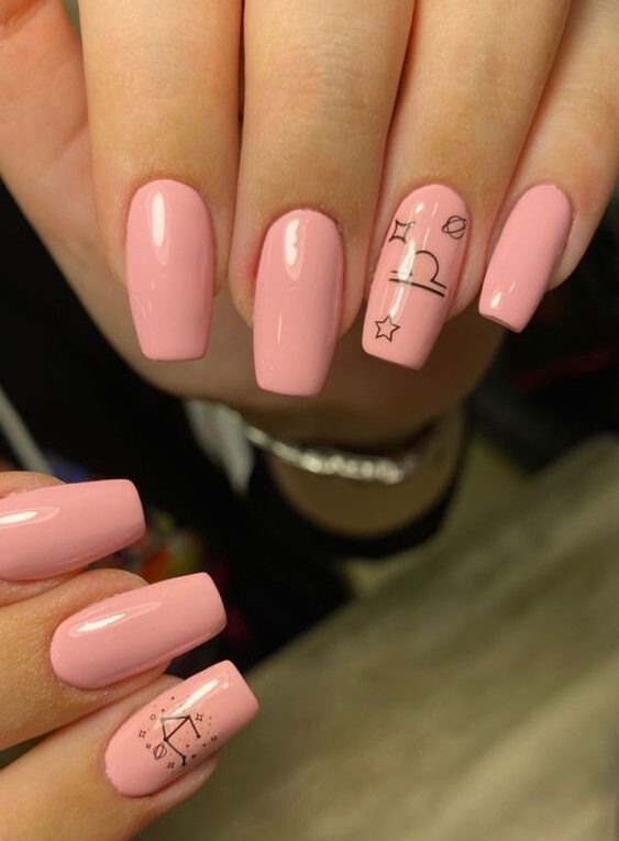 Light pink nail polish with Libra sign and constellation nail arts on long tapered square nails